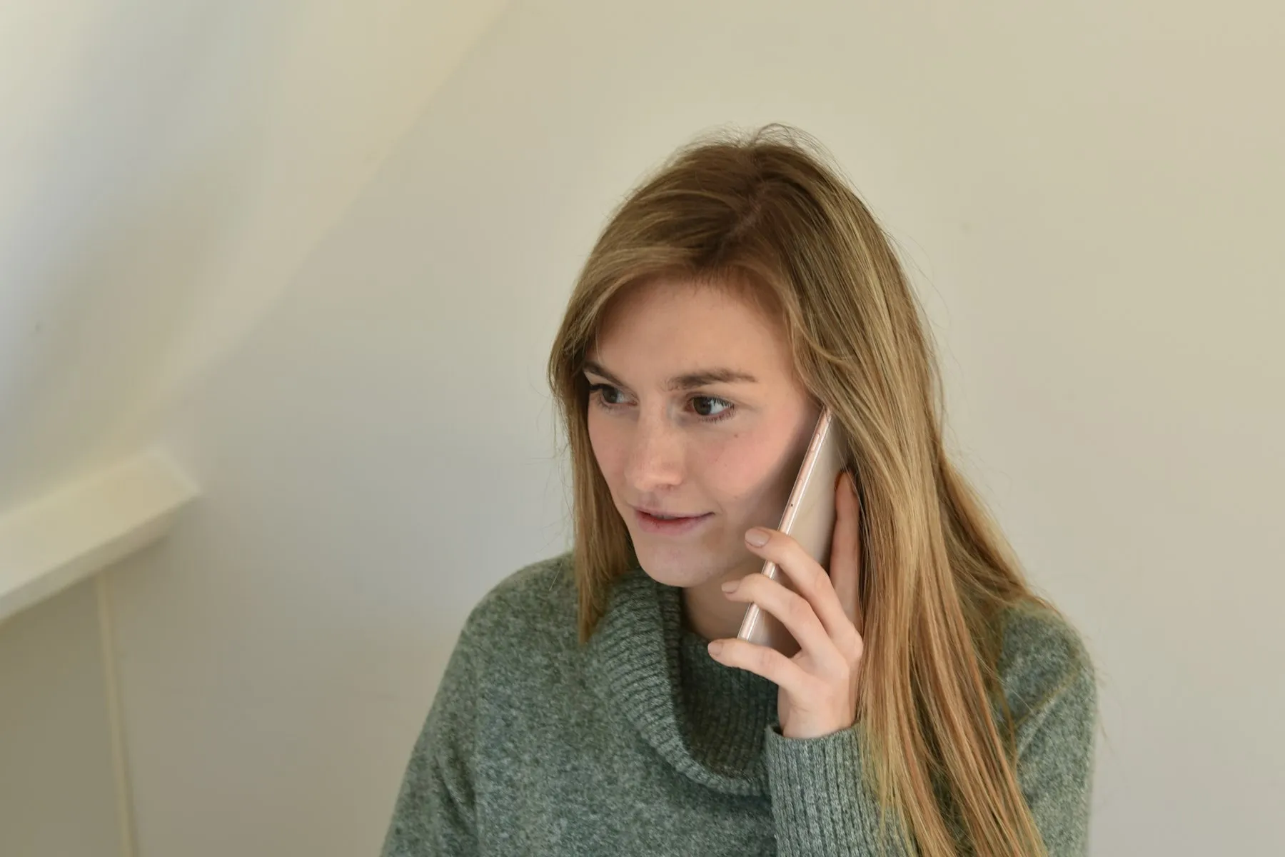 A woman at a desk talking on her cell phone
